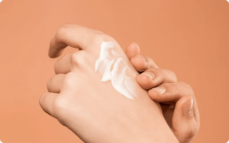 a person applying cream on the hand