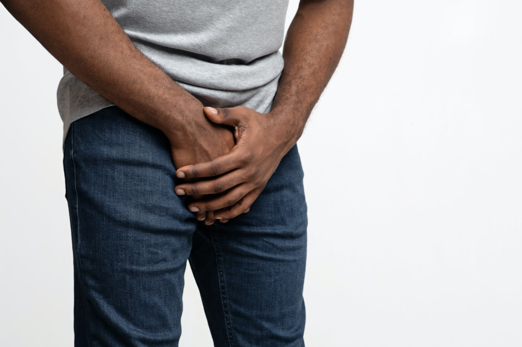 Male holding groin with gonorrhea